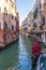 A canal and its facades and gondolas in Venice in Veneto, Italy