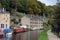 The canal and marina in hebden bridge with boats on the water, towpath and surrounding hillside trees