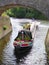 Canal narrowboat passing under bridge