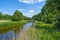 Canal with reed in a rural area below a blue  sky in sunlight in spring