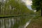 Canal with reflection of trees in the Flemish countryside