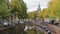 Canal running through an urban cityscape with cars parked along the banks