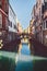 Canal in sunshine with bridge in Venice, Italy.