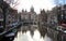 Canal and townhouses in the historic heart of the city, Basilica of Saint Nicholas in the background, Amsterdam, Netherlands