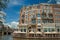 Canal with typical brick building, restaurant, bridge and blue sky in Amsterdam.