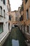 Canal in Venice with docked gondola and boats,