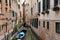 Canal in Venice with docked gondola and boats,