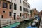 Canal in Venice with docked gondola and boats,