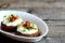 Canape with cottage cheese, mushrooms and green onion on a plate on a wooden background