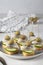 Canape with salted herring, olives and cucumber on white bread toasts on light gray background