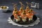 Canape with shrimp, pineapple and olives - festive bright appetizer on dark gray background