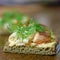 Canape with smoked Arctic char, paprika cream cheese and dill on rye bread