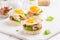 Canapes with fried mushrooms, quail egg, soft cheese and basil,