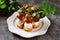 Canapes of mozzarella, green olives, cherry tomatoes, basil on croutons of white bread.