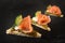 Canapes in a row with smoked salmon, cucumber, pesto and dill ga