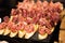 Canapes sandwiches with jamon and sauce. Plate with delicious meat bruschettas. Catering food concept