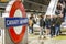 Canary Wharf underground sign with a crowd of commuters