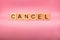 CANCEL word made with building blocks, business concept. Word CANCEL on pink background.