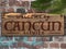 Cancun Mexico Welcome sign engraved in wood on a brick wall tropical