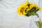 Candid authentic Yellow sunflowers bouquet on fabric white background. Background with bouquet of yellow sunflowers on