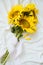 Candid authentic Yellow sunflowers bouquet on fabric white background. Background with bouquet of yellow sunflowers on