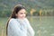 Candid girl warmly clothed in a lake looks away