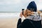 Candid photo of hipster girl traveler on sand shore at winter