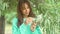 Candid portrait of attractive brunette woman smiling to camera and looking happy, standing at green olive tree. girl in