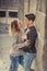 Candid portrait of beautiful European couple with rose in love kissing on street alley celebrating Valentines day