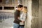 Candid portrait of beautiful European couple with rose in love kissing on street alley celebrating Valentines day