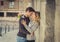 Candid portrait of beautiful European couple with rose in love kissing on street alley celebrating Valentines day