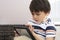 Candid shot of School kid playing game on tablet with serious face, Cropped shot Child boy concentrated watching cartoon on touch