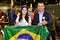 Candidate for State Representative Juciane Cunha with candidate for Federal Deputy Captain Souza hold the flag of Brazil together