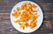 Candied fruit on the plate. Dried homemade oranges. Wooden background