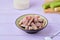 Candied rhubarb, sprinkled with powdered sugar, in a ceramic plate on a purple wooden background. Preparations, conservation.