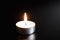 A candle on a black background has just gone out,