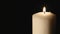 Candle blown out. The candle is lit and extinguished in the dark. White candle. Black background