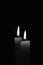 Candle burning in the black background. Black and white photo