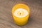 The candle burns in a yellow glass. Fragrant candles, gentle warm fire