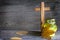 Candle and cemetery cross on wooden background in autumn