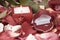 Candle and a diamond ring on a background of rose petals