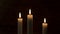 A candle fire. Three candles on a dark background.