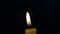 Candle flame on a black background swaying from a little wind, background, free space for text