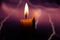 Candle flame on blurred background spark of lightning close-up