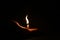 Candle in hand. Small candle with a curved flame. Complete darkness.