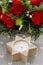 Candle holder in star shape in front of floral christmas decoration