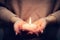 Candle light glowing in woman\'s hands. Praying, faith, religion