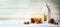 candle light lantern with pine cones, nuts and tangerines as christmas decoration on a wide, bright wooden background, panoramic