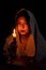 Candle light with young girl praying in dark night background. Woman person worship God with faith and belief. religion, christian