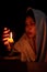 Candle light with young girl praying in dark night background. Woman person worship God with faith and belief. religion, christian